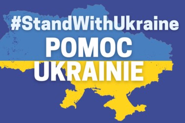 Mapa terytorium Ukrainy utrzymana w kolorach niebiesko-żółtym, na pierwszym planie napis #standwithUkraine pomoc ukrainie